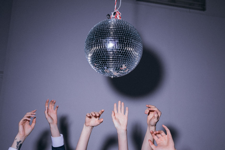 Retro disco party with people dancing under colourful lights