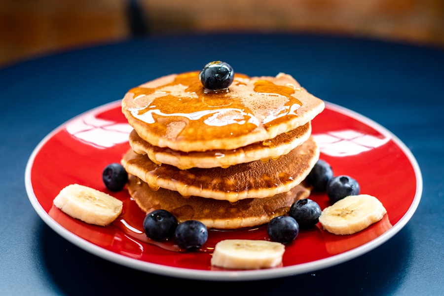 Stack of golden blini with honey