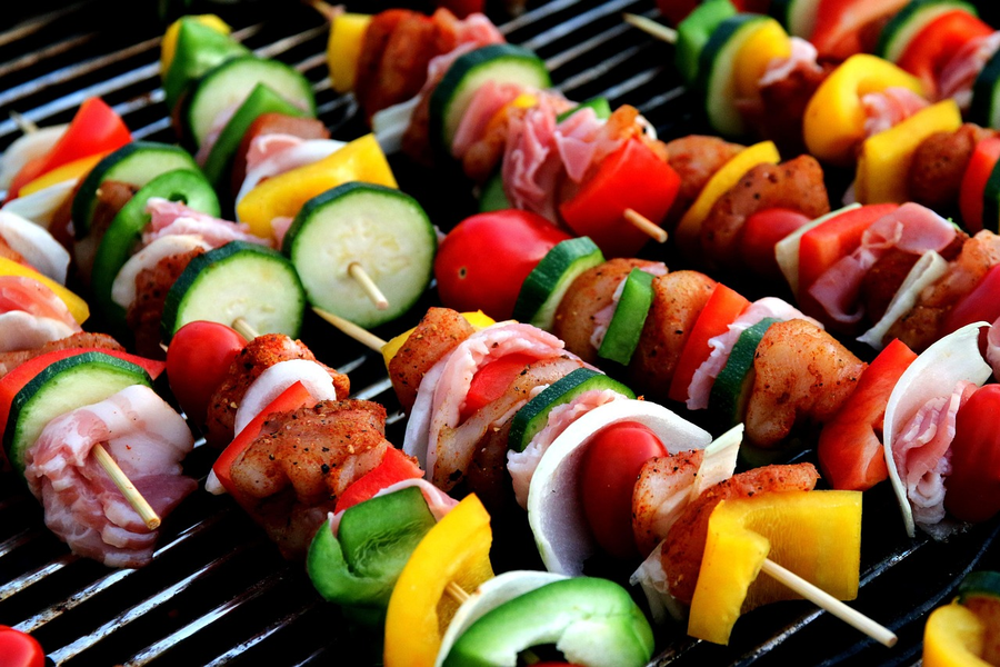 Shashlik skewers grilling at a summer park picnic